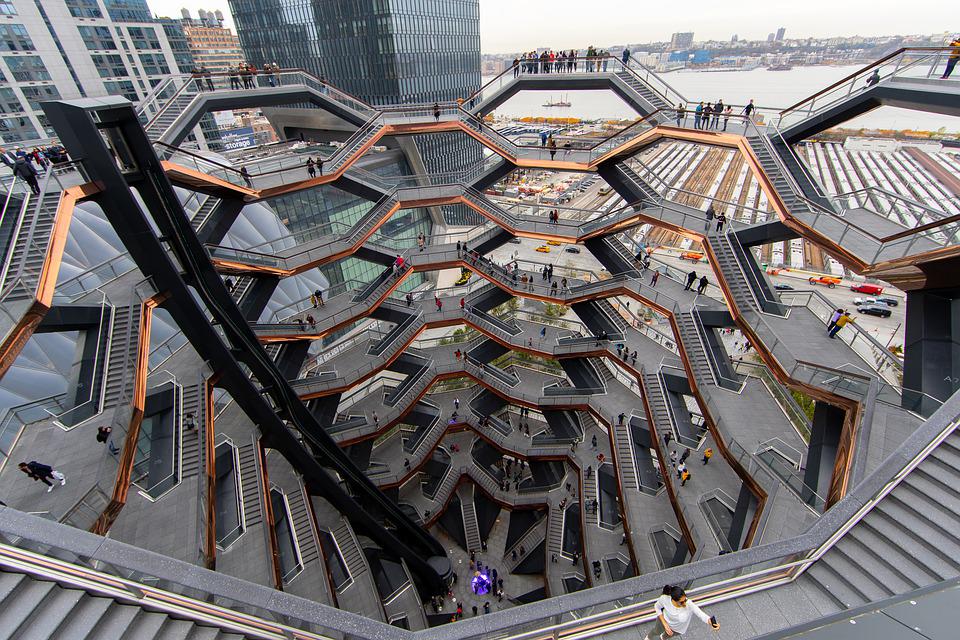 Image taken on the top of the vessel locking down to the bottom. The vessel is shaped like a honeycomb vase. Its construction is made of concrete-stairs, with a shiny copper underside.